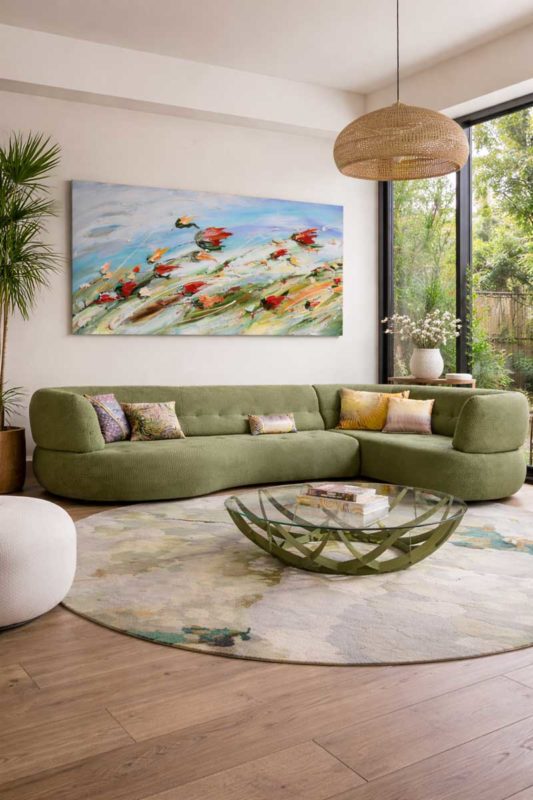Tableau abstrait très grand format 1x3 mètres création originale contemporaine dans salon lumineux au-dessus canapé vert intérieur architecture moderne